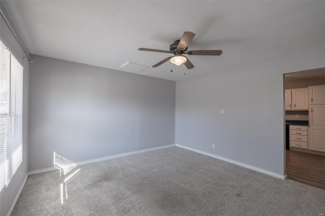 carpeted empty room with ceiling fan and baseboards