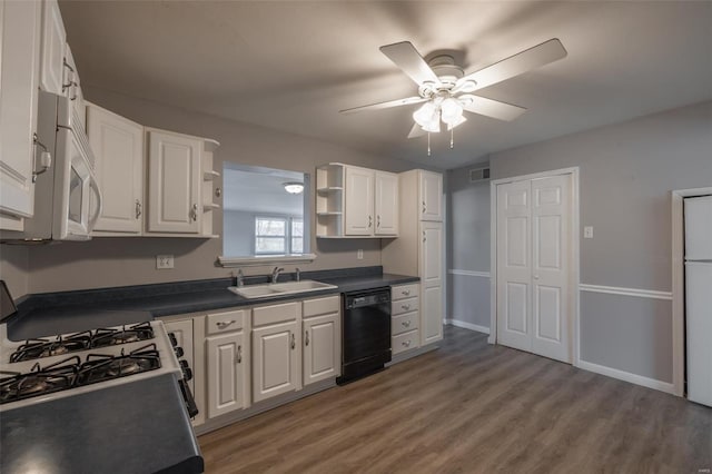 kitchen with white appliances, a sink, white cabinets, open shelves, and dark countertops