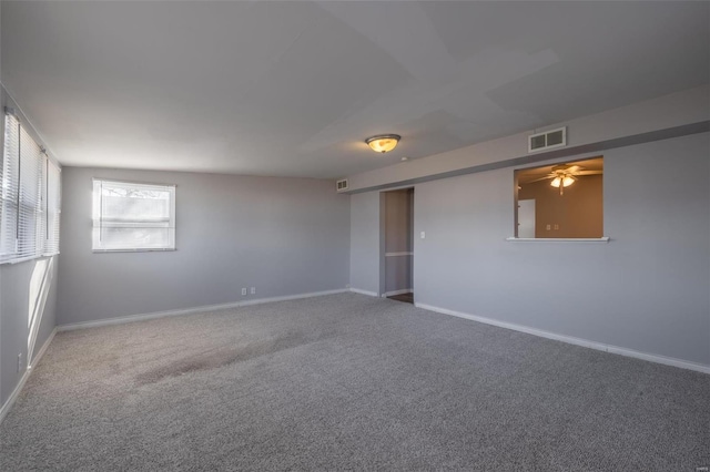 empty room featuring baseboards, visible vents, and carpet flooring