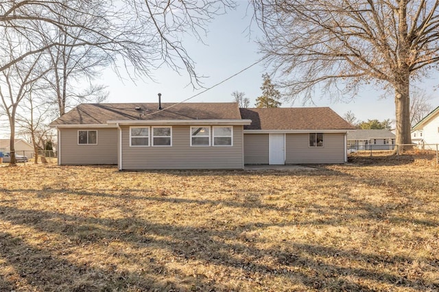 back of property featuring a yard and fence