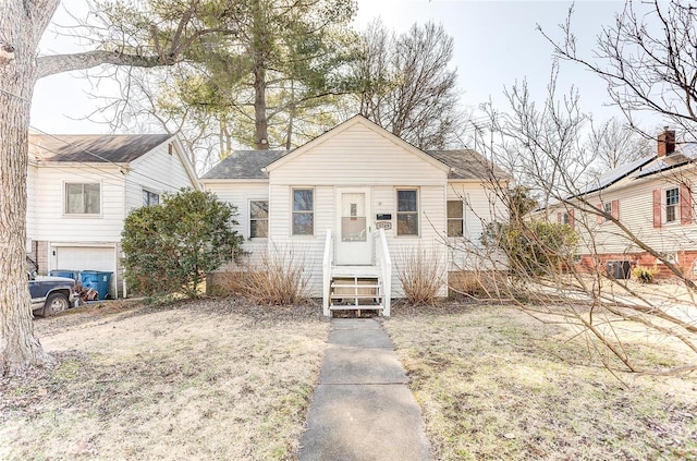 bungalow with an attached garage and roof with shingles