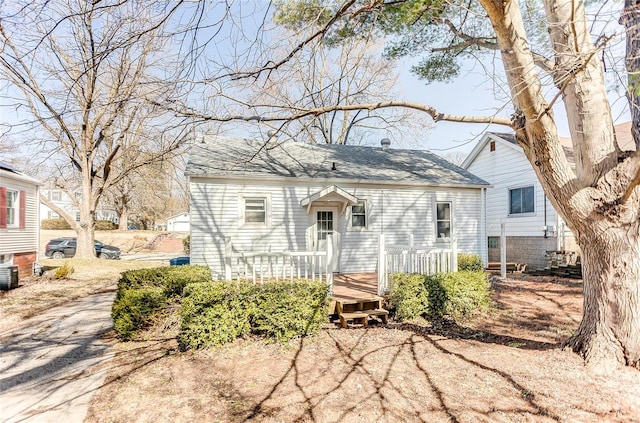 view of front of home with a shingled roof and a deck