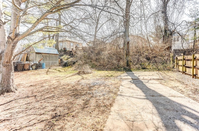 view of yard featuring fence and an outbuilding