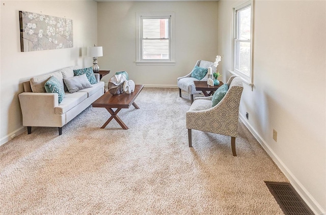 carpeted living room featuring visible vents and baseboards