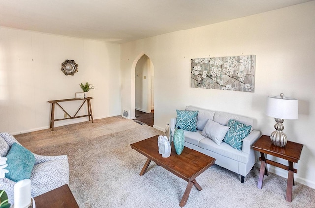 living room with arched walkways, carpet flooring, and baseboards