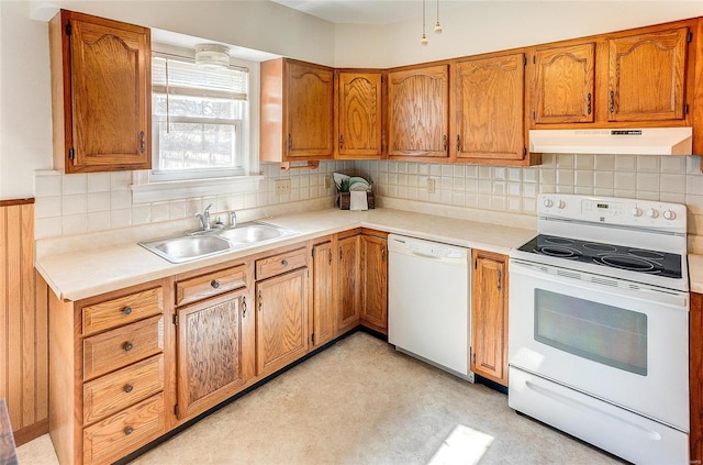 kitchen with white appliances, tasteful backsplash, light countertops, under cabinet range hood, and a sink