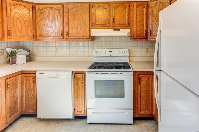 kitchen featuring white appliances, under cabinet range hood, brown cabinets, and light countertops