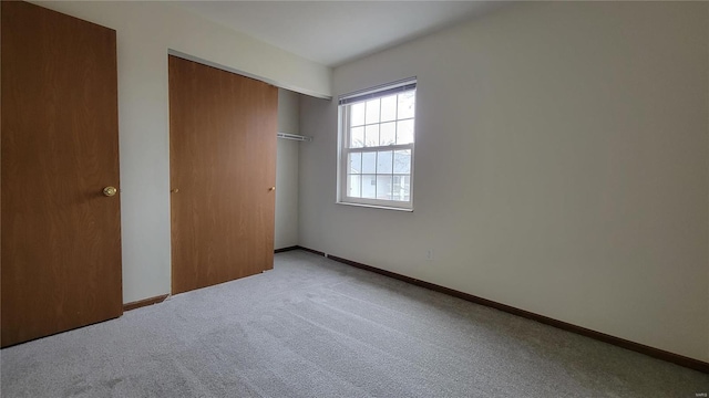 unfurnished bedroom featuring a closet, carpet, and baseboards