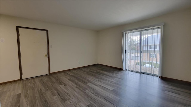 spare room with dark wood-style floors and baseboards