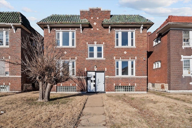 view of front of house featuring brick siding and a tile roof