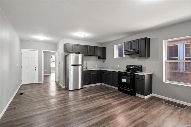 kitchen with light countertops, visible vents, black range with electric stovetop, dark wood-type flooring, and freestanding refrigerator