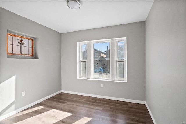 empty room with baseboards and wood finished floors