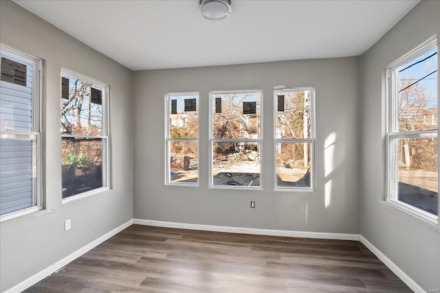 spare room featuring wood finished floors and baseboards