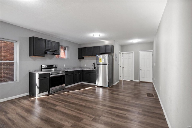 kitchen with under cabinet range hood, visible vents, light countertops, appliances with stainless steel finishes, and dark wood-style floors