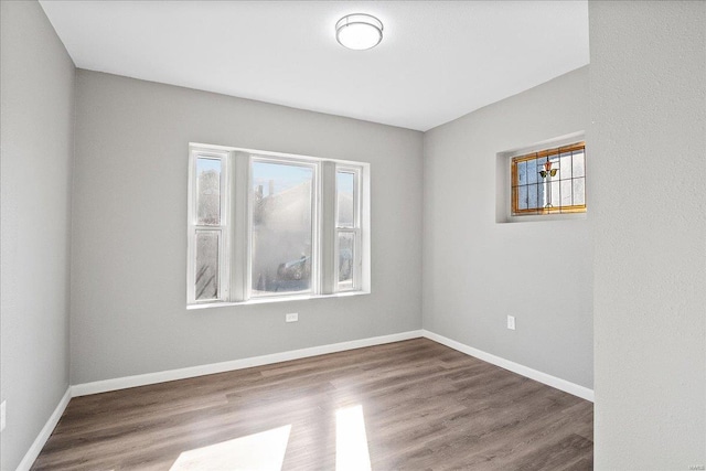 unfurnished room featuring baseboards and wood finished floors