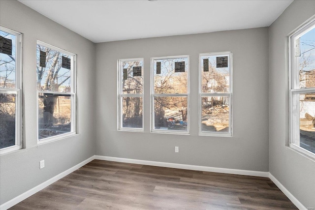 empty room with dark wood-style floors and baseboards