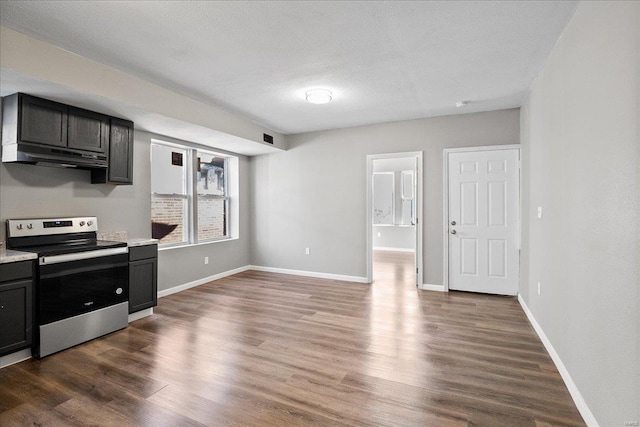 kitchen featuring electric stove, dark wood finished floors, light countertops, under cabinet range hood, and baseboards