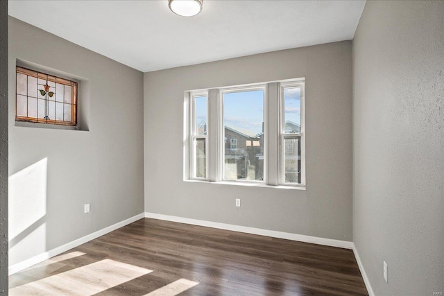 unfurnished room featuring baseboards and wood finished floors