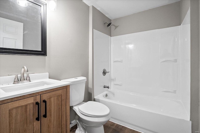 full bath featuring wood finished floors, shower / washtub combination, vanity, and toilet