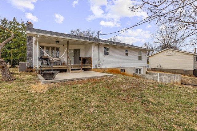 rear view of property with a yard, a chimney, a patio, and central air condition unit