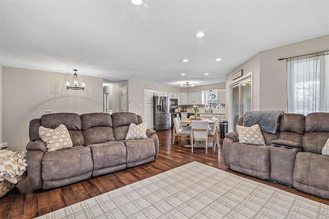 living area featuring a notable chandelier, dark wood-style flooring, recessed lighting, and a healthy amount of sunlight