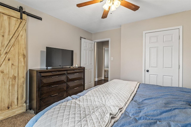 bedroom with carpet, a barn door, and a ceiling fan