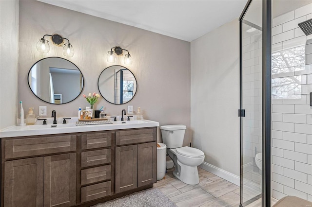 full bathroom with a stall shower, a sink, toilet, and double vanity