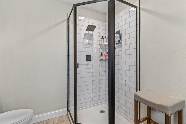 full bath featuring a stall shower, toilet, and baseboards