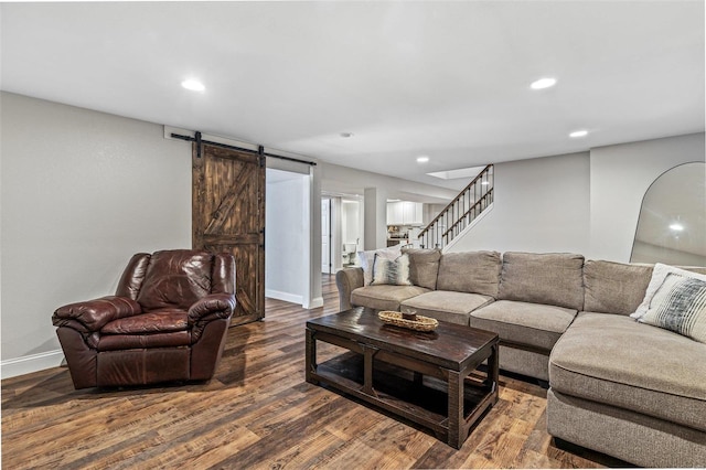 living room with a barn door, stairway, wood finished floors, and recessed lighting