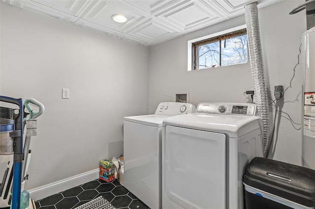 clothes washing area featuring washing machine and dryer, laundry area, and baseboards