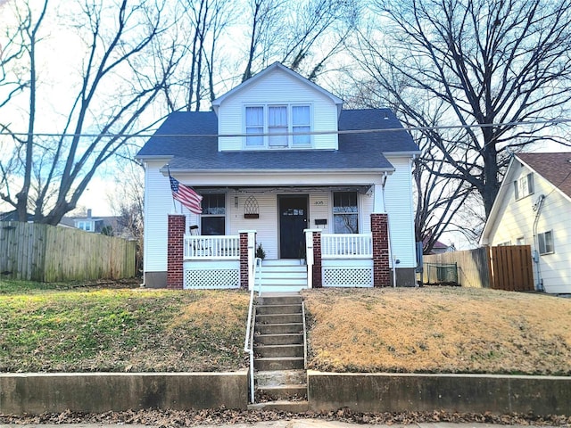 bungalow-style home with fence, a porch, and a front yard