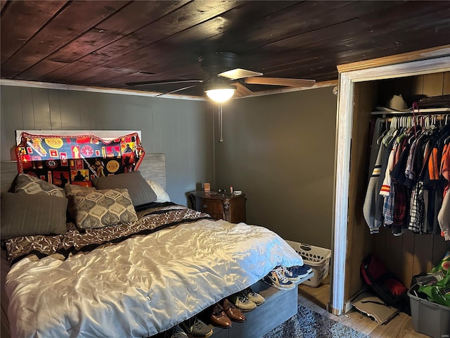 bedroom featuring wooden ceiling, a ceiling fan, and a closet