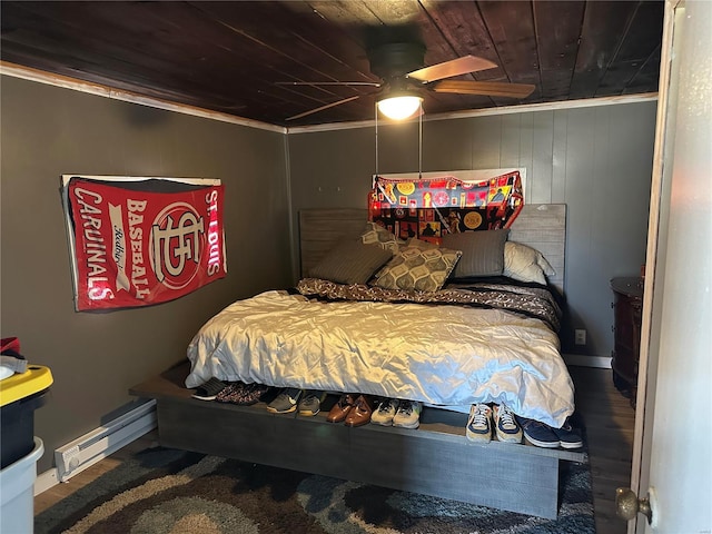 bedroom with wooden ceiling, a baseboard radiator, ornamental molding, and wood finished floors