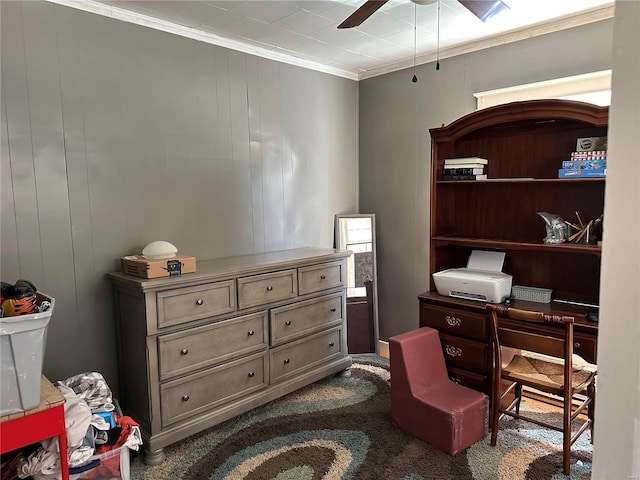 office area with ornamental molding, dark colored carpet, and a ceiling fan