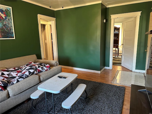 living room with ornamental molding, wood finished floors, and baseboards