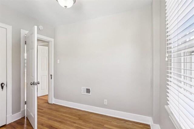 unfurnished bedroom with visible vents, baseboards, and wood finished floors