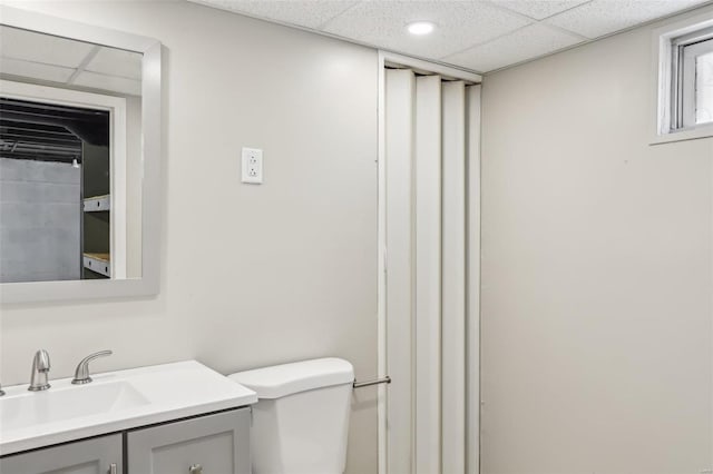 bathroom featuring a paneled ceiling, vanity, and toilet