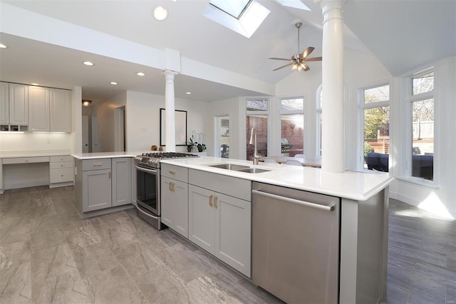 kitchen featuring stainless steel appliances, lofted ceiling, light countertops, gray cabinetry, and a sink