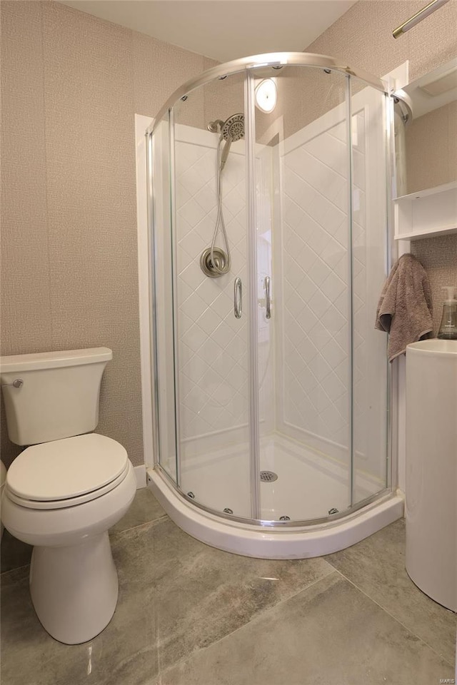 full bathroom with toilet, a stall shower, and tile patterned flooring