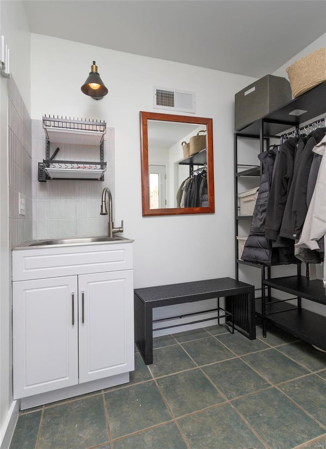 bathroom featuring visible vents, vanity, and decorative backsplash