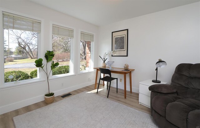 home office with light wood-type flooring, baseboards, and visible vents