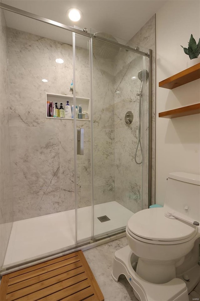 full bathroom with a marble finish shower and toilet