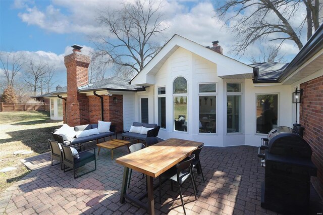 view of patio featuring grilling area, fence, and an outdoor living space