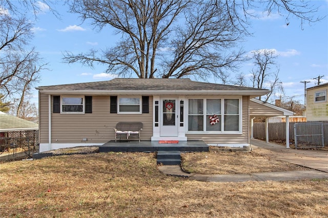 bungalow featuring a carport, fence, driveway, and a front lawn