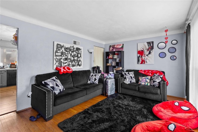 living room featuring visible vents and wood finished floors