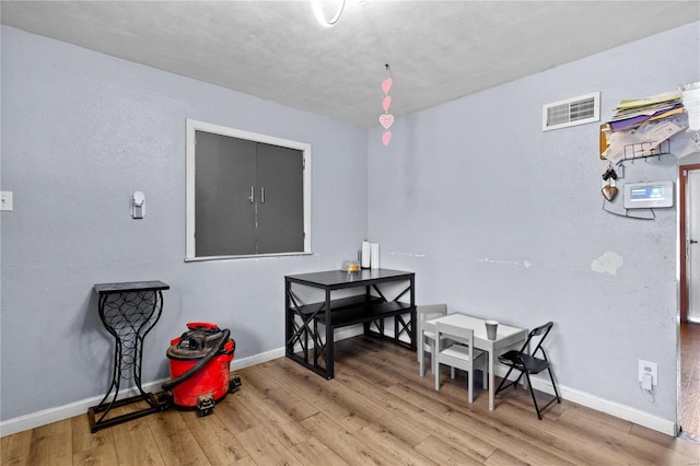 dining area with visible vents, baseboards, and wood finished floors