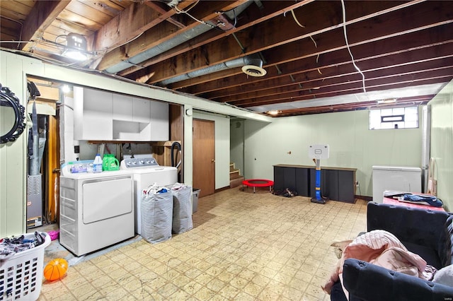 basement with light floors, fridge, stairs, and washer and clothes dryer