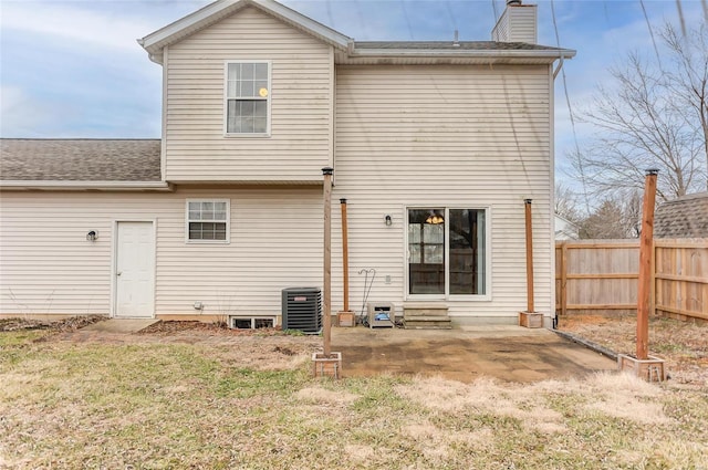 back of property featuring a yard, a chimney, entry steps, a patio area, and fence