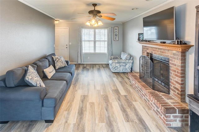 living room with ceiling fan, ornamental molding, a fireplace, and wood finished floors