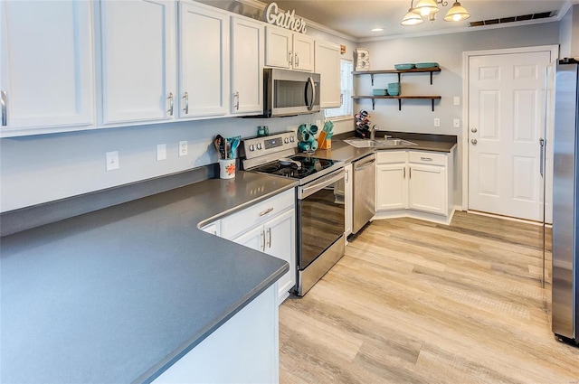 kitchen featuring open shelves, dark countertops, appliances with stainless steel finishes, white cabinets, and a sink